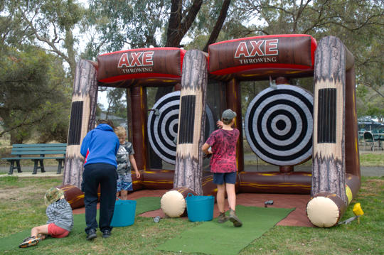 A Family of four enjoying inflatable axe throwing activity at Wild Weekender.