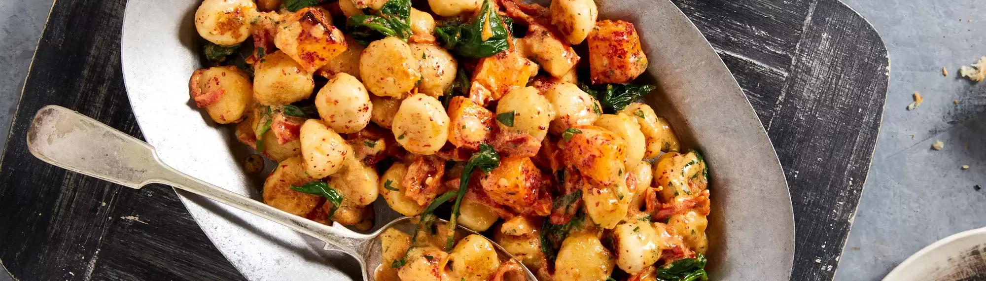 Close up of a plate of gnocchi with a spoon resting in it