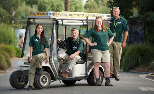 Four volunteers stand proudly with the buggy