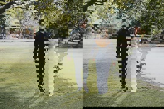 Bride and Groom Walking On Grass