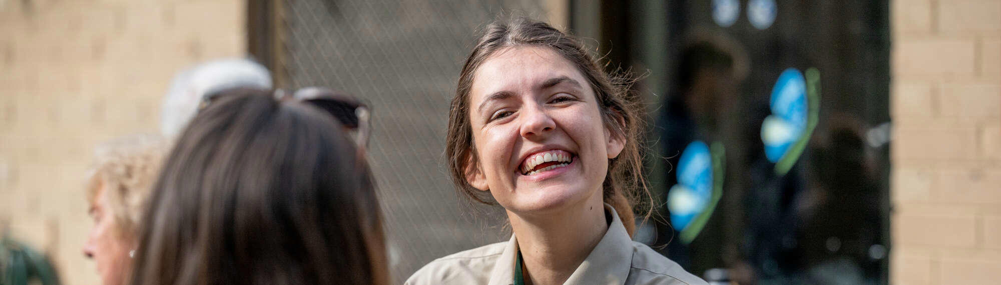 A volunteer smiling at the camera, in the company of five others.