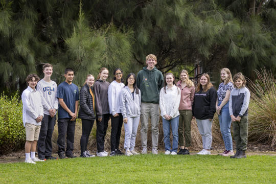 The thirteen then-active members of ZV's Youth Advisory Committee, rowed up trees and smiling to the camera.