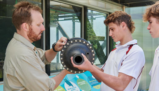 Two high school students with Melbourne Zoo educator investigating an object.
