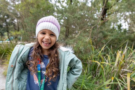 A kid wearing beanie looking at the camera, smiling