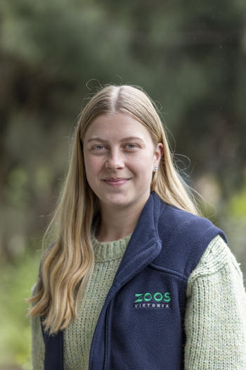 Portrait of Field Officer Nadia, in front of a leafy backdrop.
