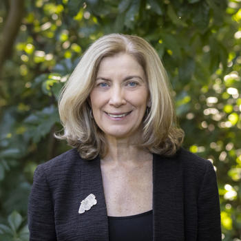 ZV CEO Jenny, smiling to the camera in front of a leafy backdrop.