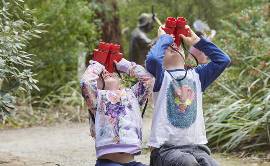 Two Kinder Kids Look Through Binoculars
