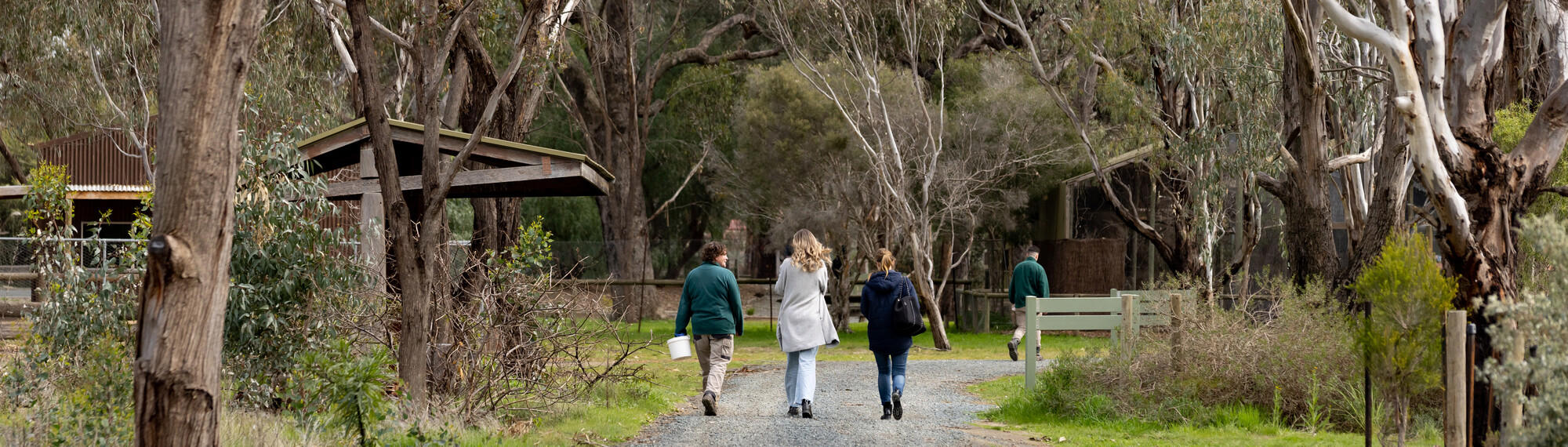 Two guests walking with a Keeper along the trail at Kyabram Fauna Park.