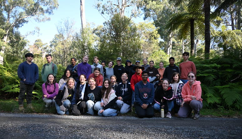 Thirty-two students (youth conservation leaders) posing for the camera, against a leafy backdrop.