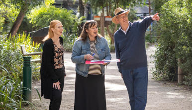 Three guests taking part in Healesville Sanctuary's Run Around the Zoo, one pointing right and another holding a blue pen and paper.