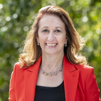 Dr Teresa De Fazio OAM looking at a camera, smiling